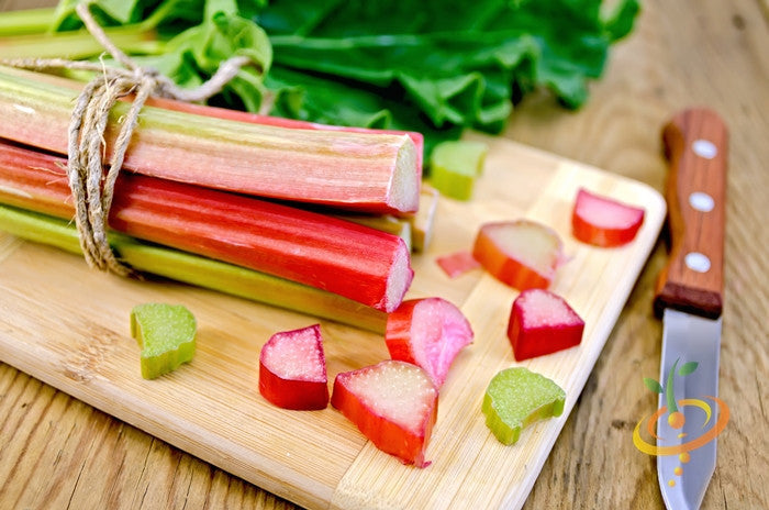 Fresh Victoria rhubarb stalks from SeedsNow, vibrant red and green rhubarb plant with lush leaves.